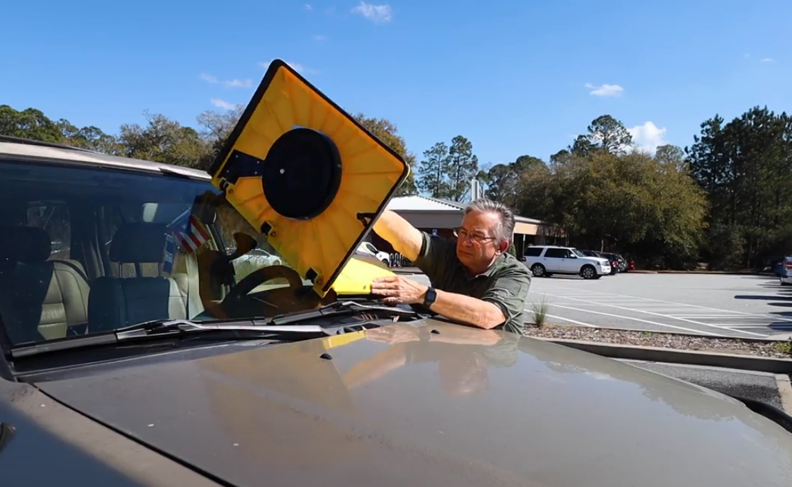 Man placing Barnacle tool onto windshield of vehicle.